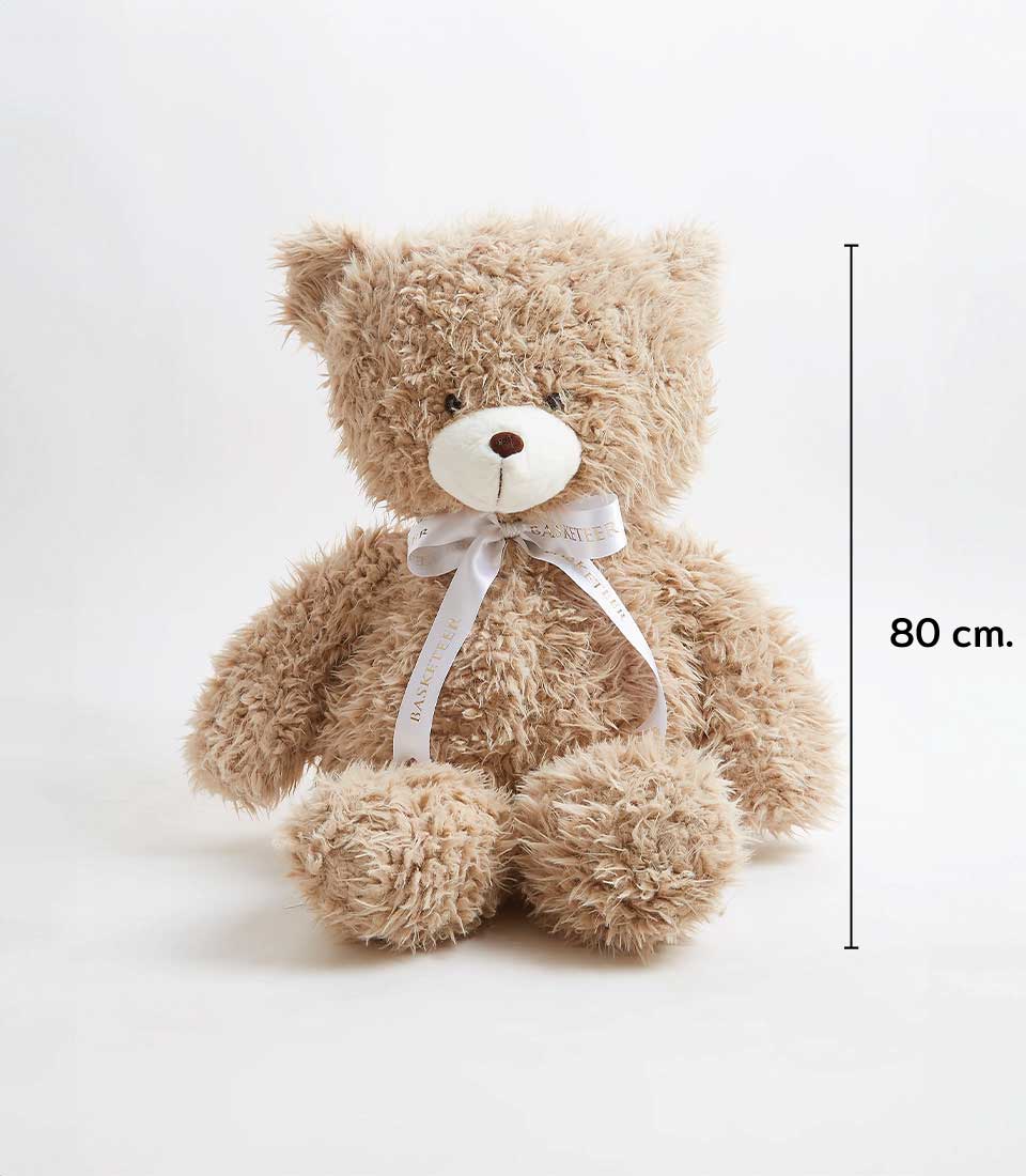 A fluffy light brown teddy bear with a white ribbon bow around its neck sits upright against a plain white background. The height of this adorable teddy bear is marked as 80 cm.