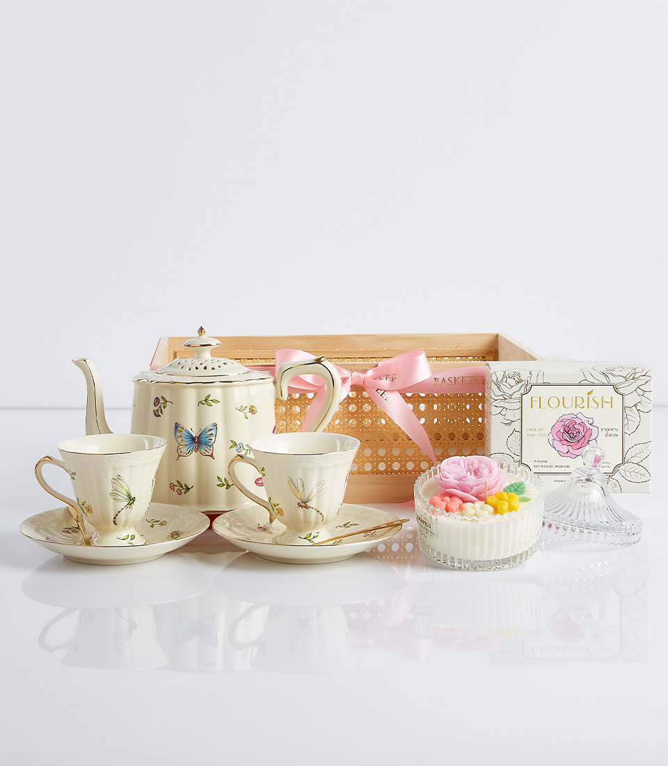 A porcelain tea set with delicate butterfly motifs, featuring a teapot, teacups, and saucers.