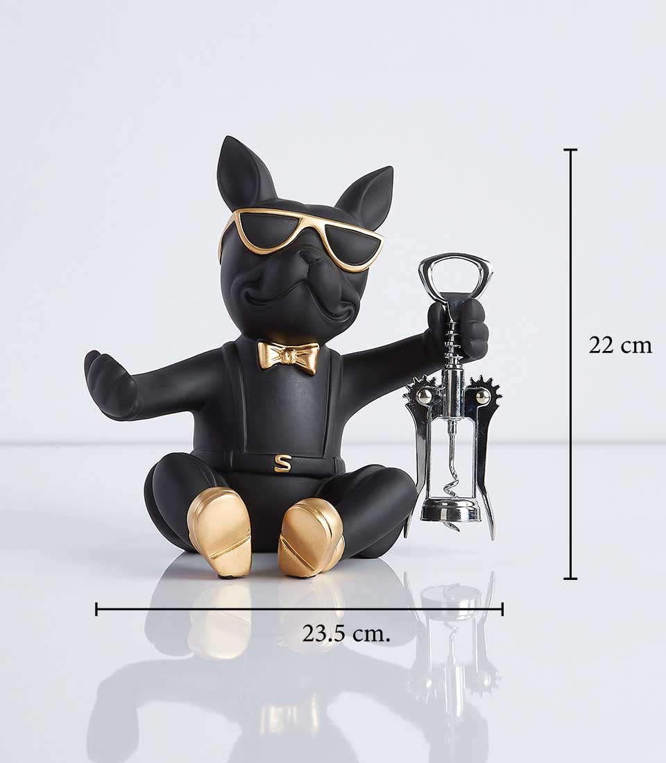 Black bulldog figurine wearing sunglasses and a bowtie, holding a corkscrew, designed to hold a wine bottle. Dimensions: 23.5 cm wide, 22 cm tall.