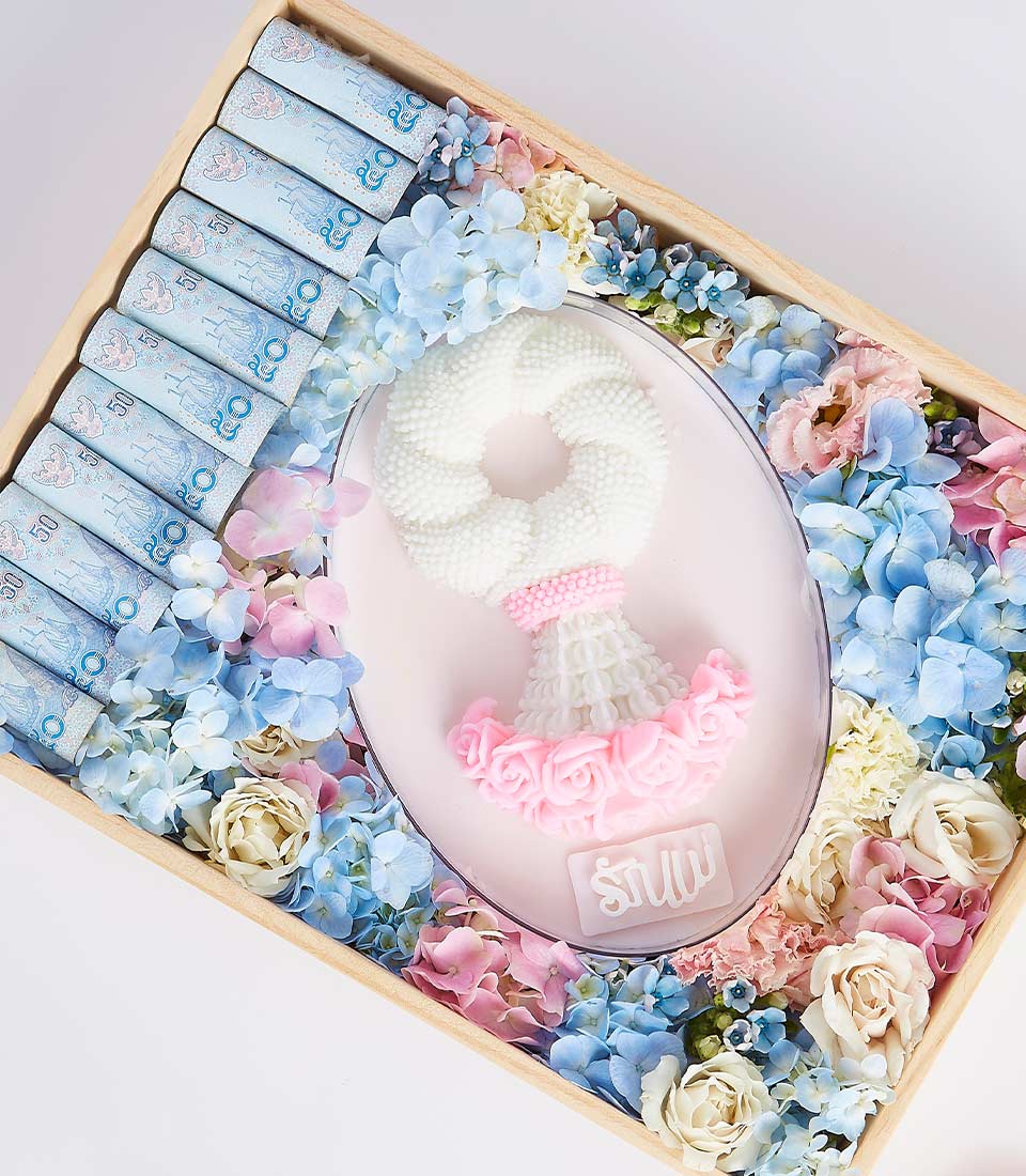 A decorative tray featuring a white garland with pink flowers, surrounded by an arrangement of blue, pink, and white flowers. Several rolled 100 Thai Baht notes are neatly placed on one side of the tray, making it a premium Mother's Day gift.