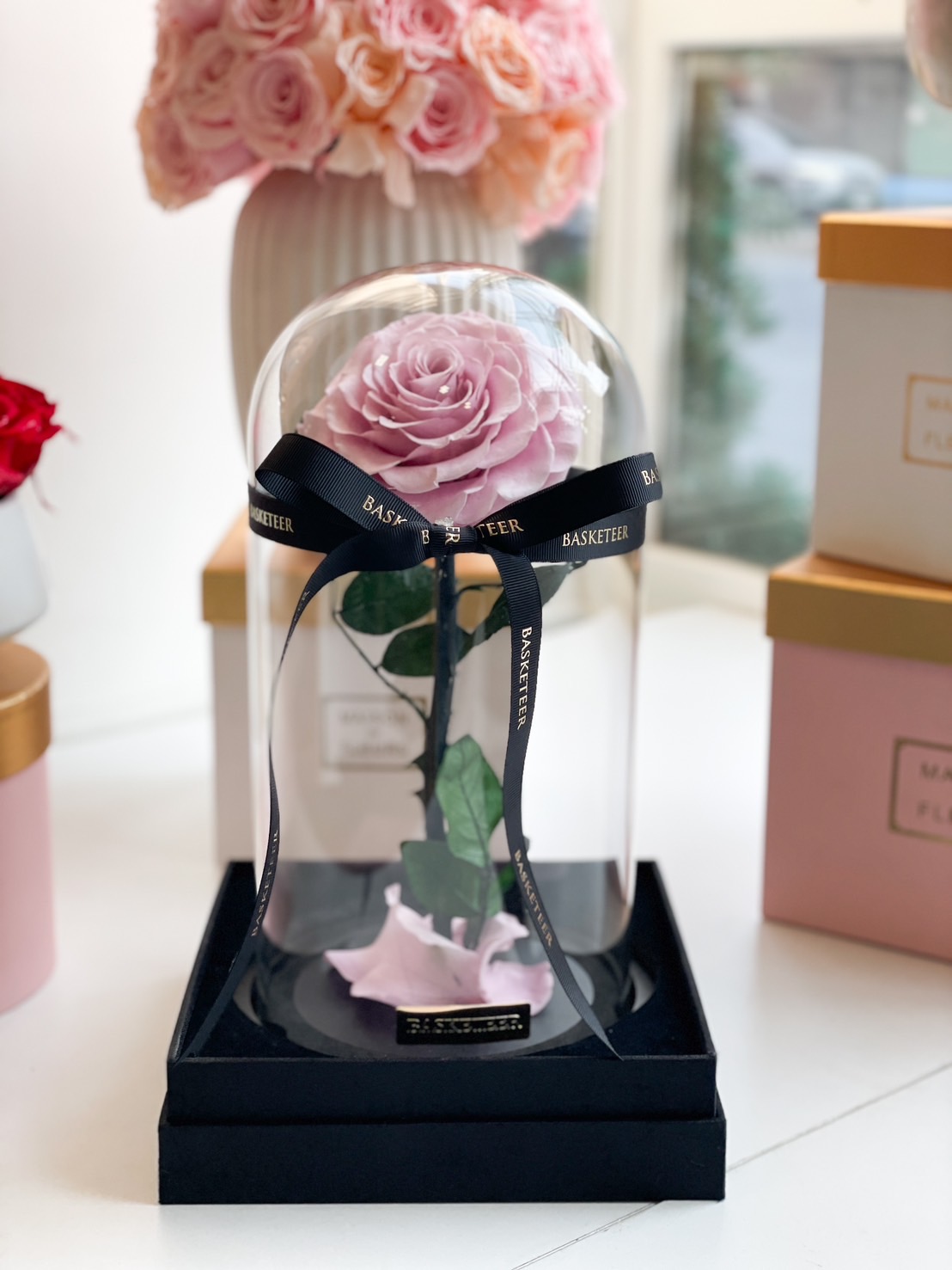 Preserved lavender rose in a glass dome with a black base, a symbol of eternal grace and elegance.
