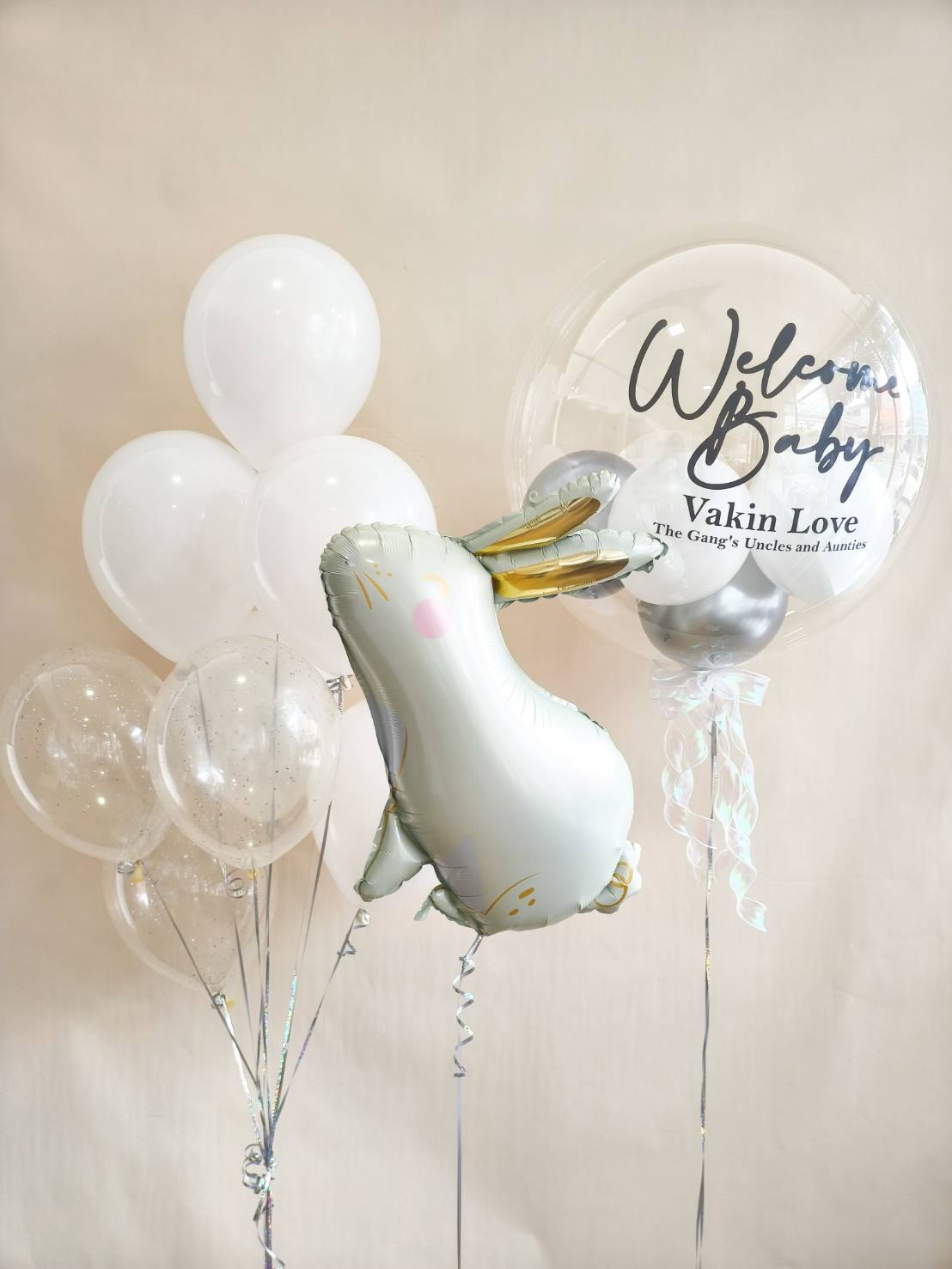 Welcome Baby balloon set with personalised clear bubble balloon, white and silver balloons, and cute bunny foil balloon.