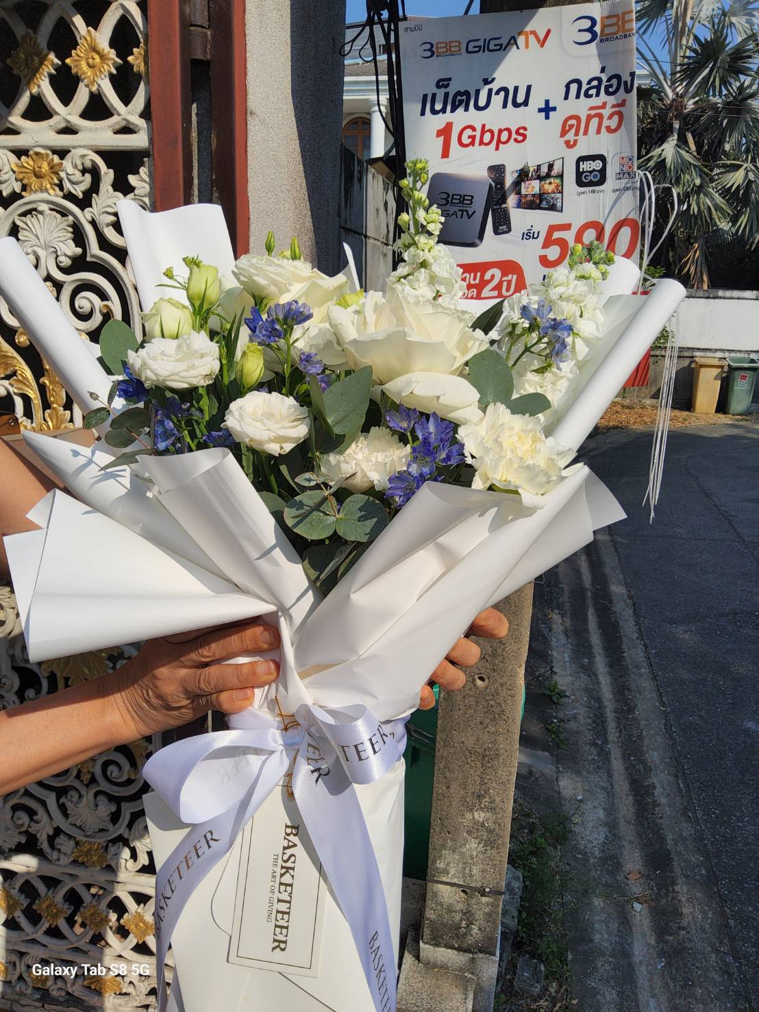 A luxurious bouquet of white and blue flowers, elegantly wrapped with a satin ribbon. Features premium roses, lisianthus, and eucalyptus for a timeless floral arrangement.