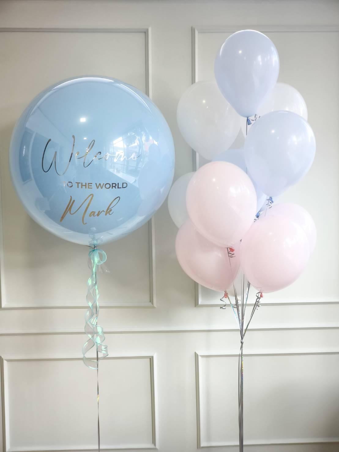 Welcome baby balloon set with large blue personalised balloon and pastel latex balloons in pink, blue, and white, perfect for baby shower decoration