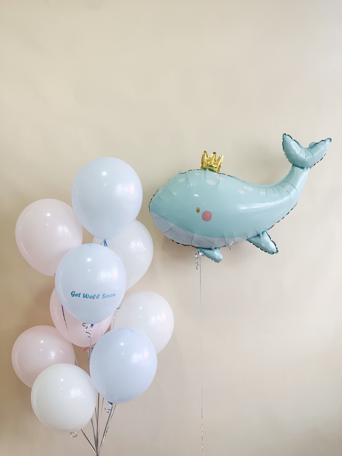 Pastel blue and white balloon bouquet with a large whale-shaped foil balloon and 