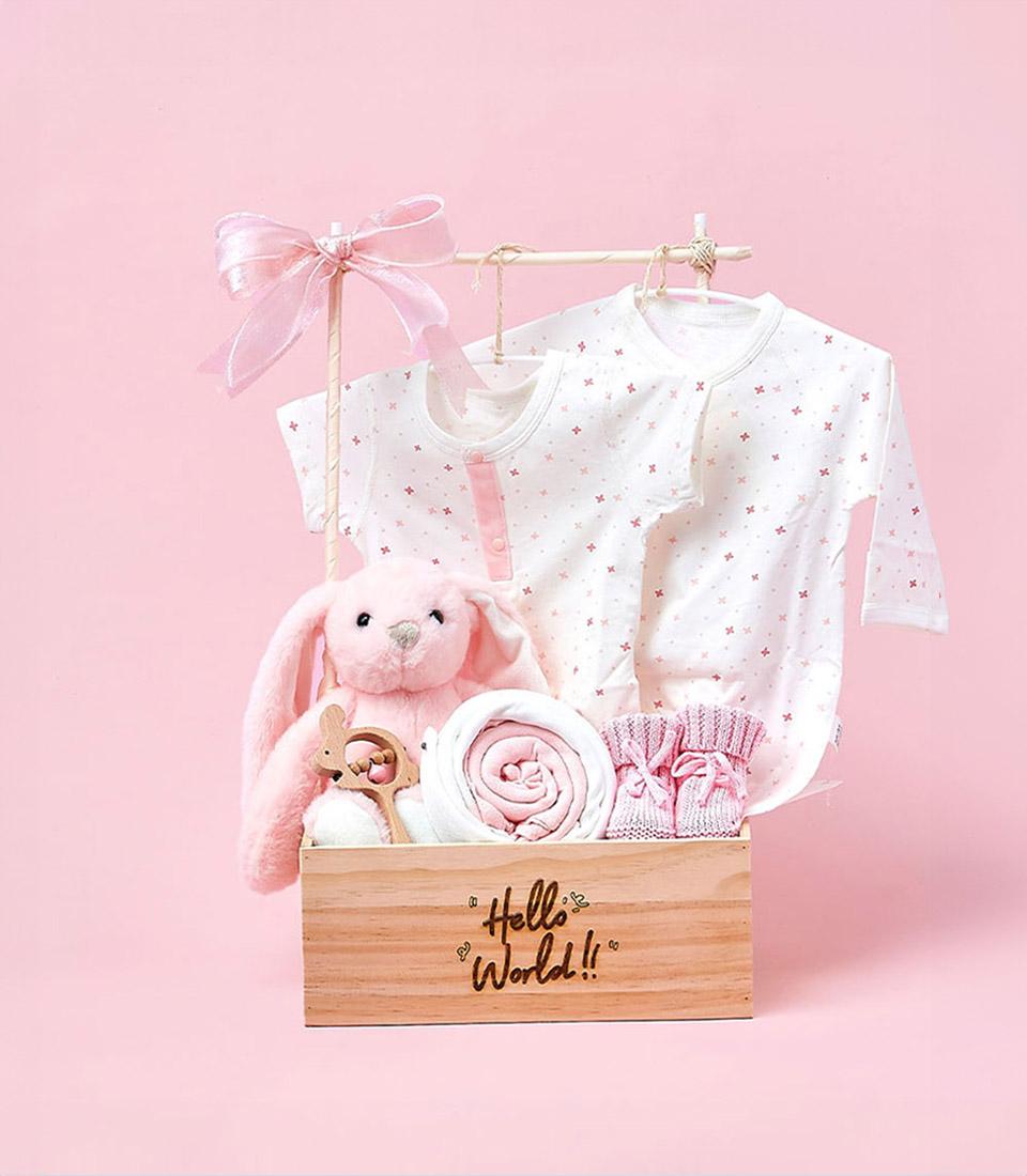 A pastel pink gift set against a pink background, showcasing 