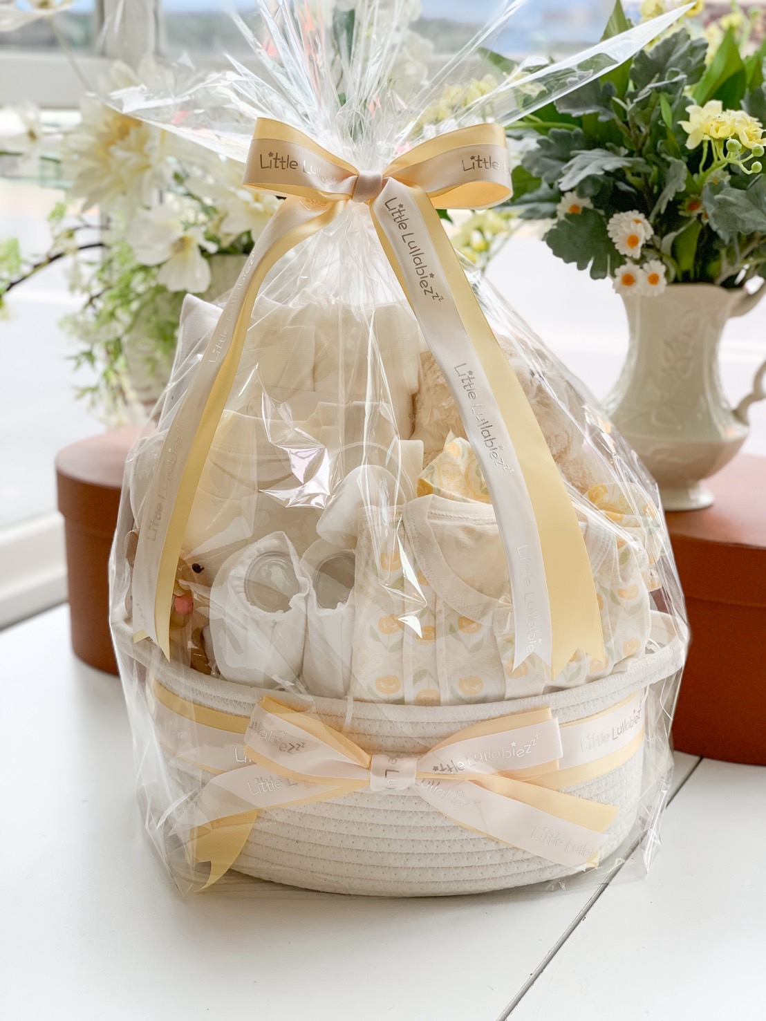 Luxury yellow baby gift basket wrapped with premium clothes, shoes, and baby essentials. Perfect newborn or baby shower gift.