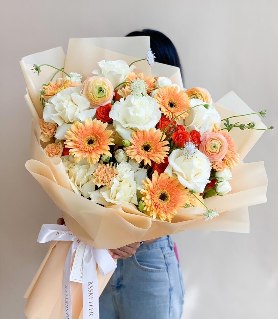 Elegant peach and cream rose bouquet with gerberas and fresh flowers, perfect for celebrations.