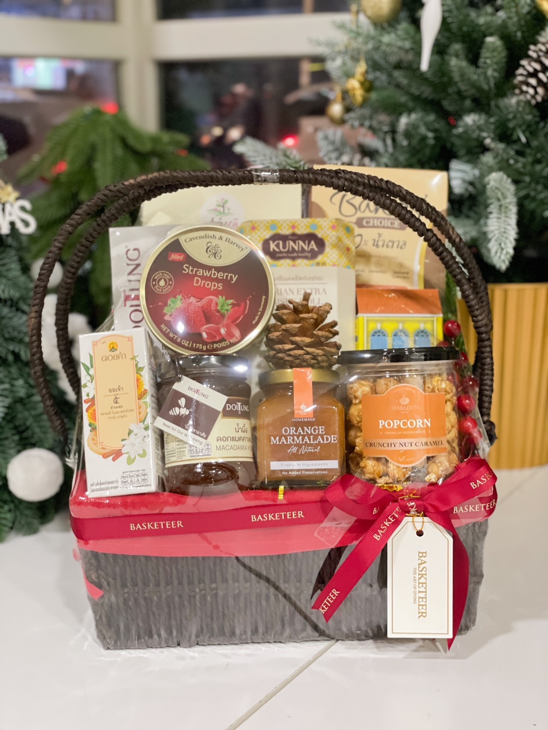 Gift basket with premium snacks including strawberry drops, orange marmalade, and caramel popcorn by Basketeer.