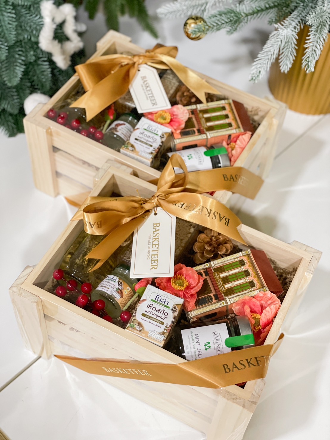 Wooden gift crate featuring gourmet condiments, herbal drinks, and festive decorations by Basketeer.