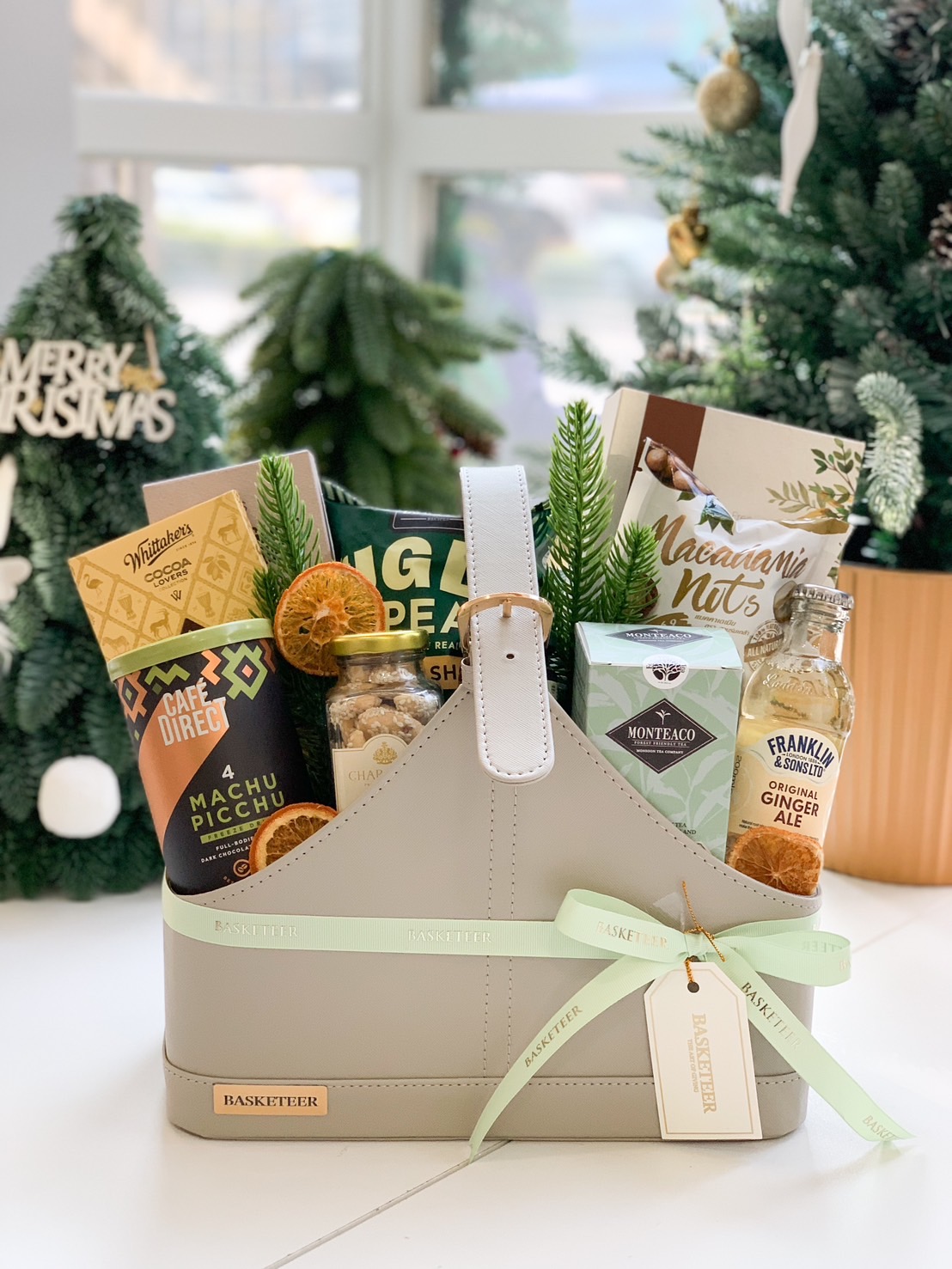 Elegant gourmet hamper with chocolates, macadamia nuts, coffee, and ginger ale in a stylish basket by Basketeer.