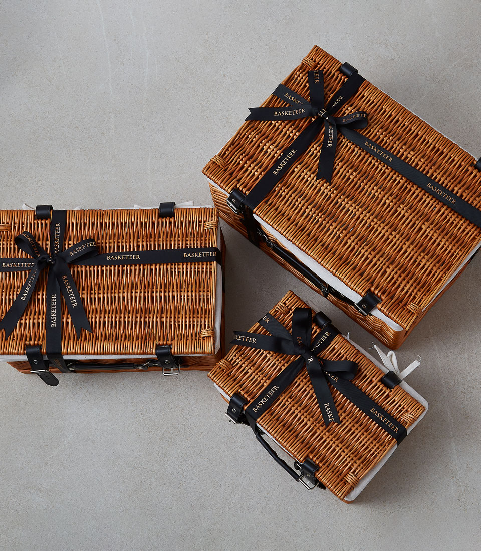 Three wicker gift baskets wrapped with black 