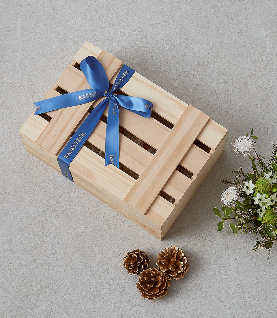 A wooden gift box tied with a blue ribbon, labeled 