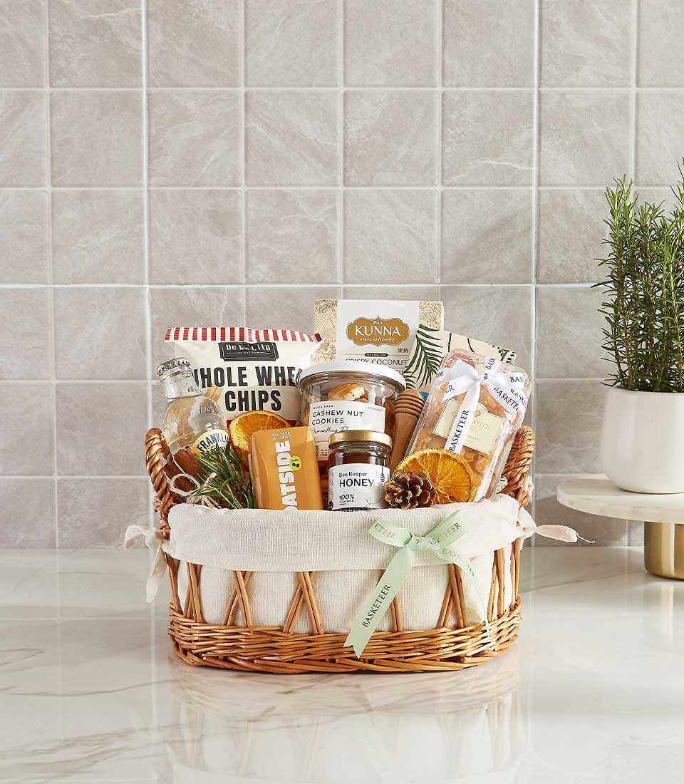 Gift basket featuring whole wheat chips, cashew nut cookies, honey, oatside bar, and dried fruits.