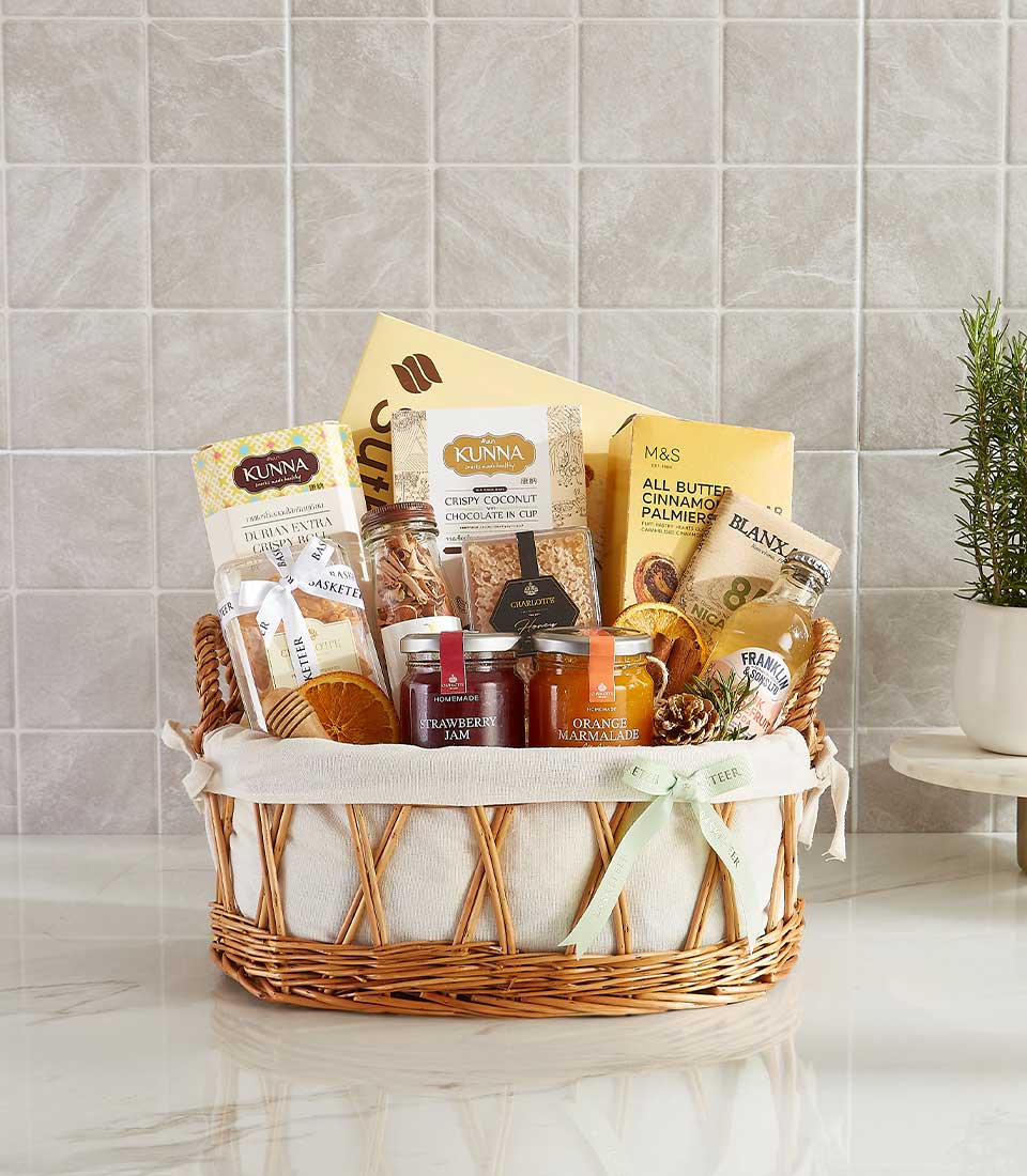 Gift basket with strawberry jam, orange marmalade, cookies, chocolates, and gourmet snacks.