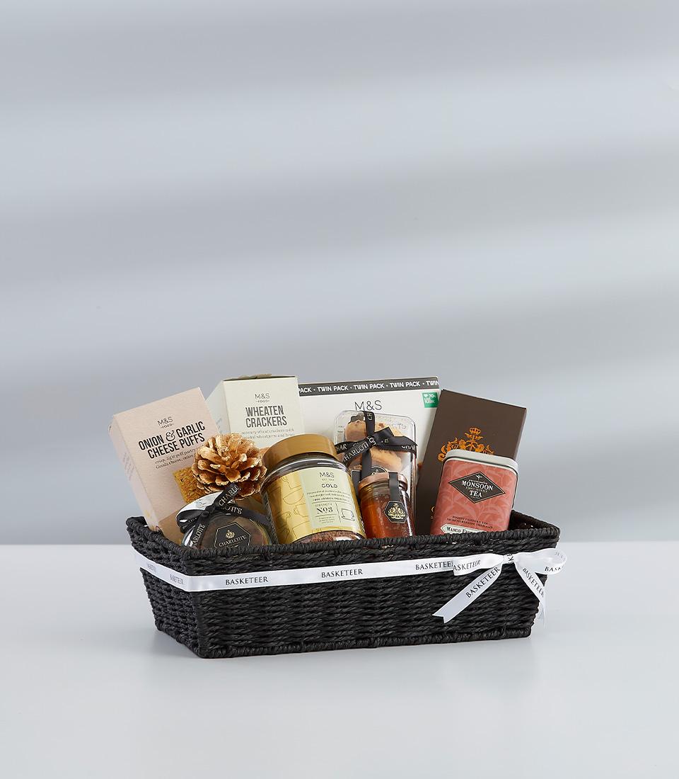 A festive gift basket featuring a selection of sweet and savory treats, perfect for sharing with loved ones.