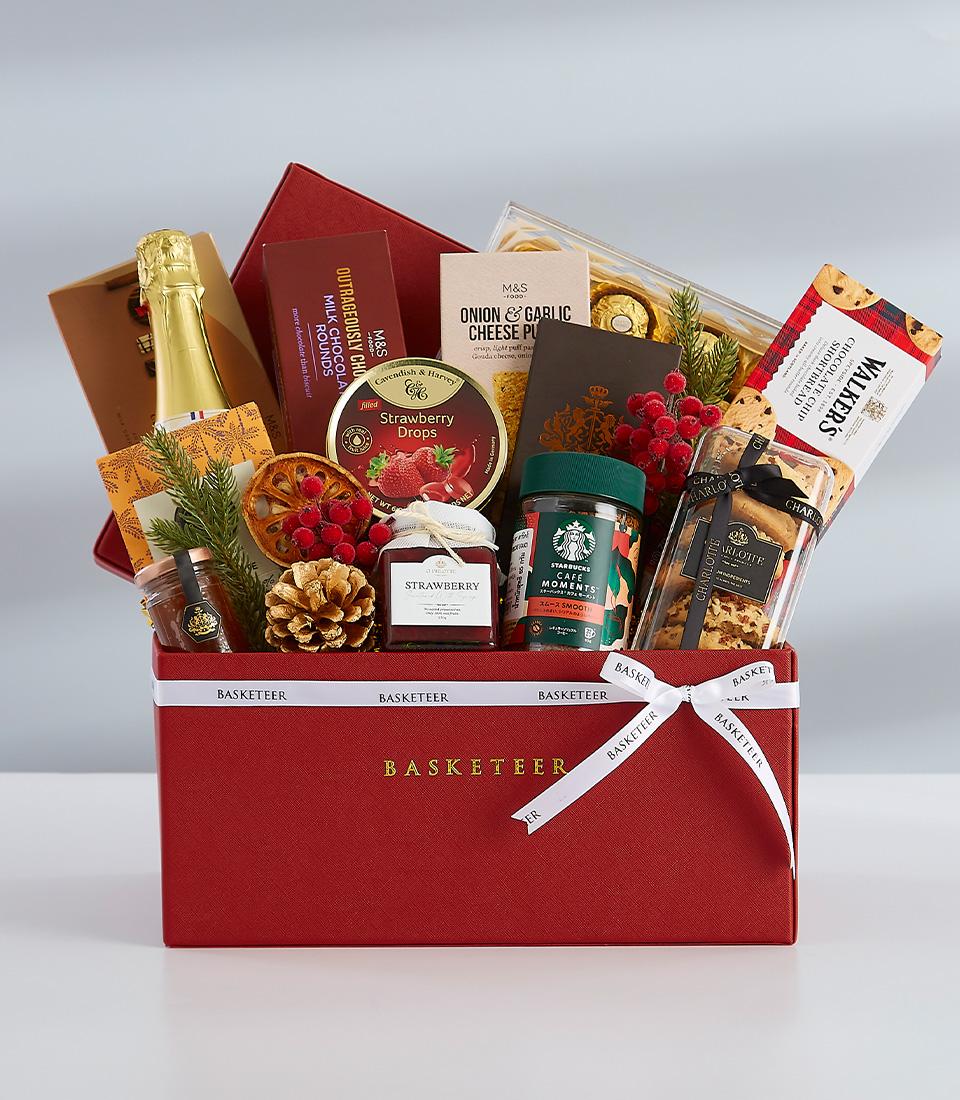 A luxurious gift box filled with gourmet delicacies, including chocolate, biscuits, and sparkling wine.