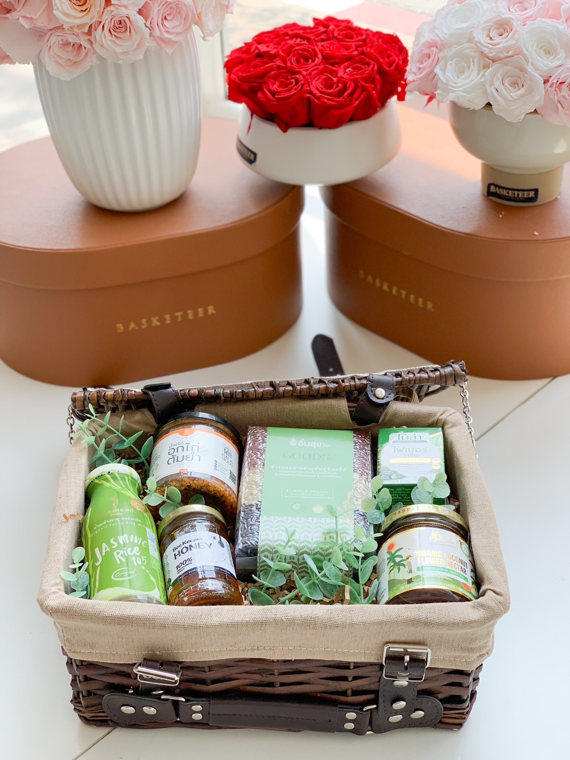 A beautifully curated organic wellness gift basket, featuring Thai jasmine rice, honey, organic coconut nectar, and herbal-infused products in a stylish woven picnic basket—perfect for health-conscious gifting.