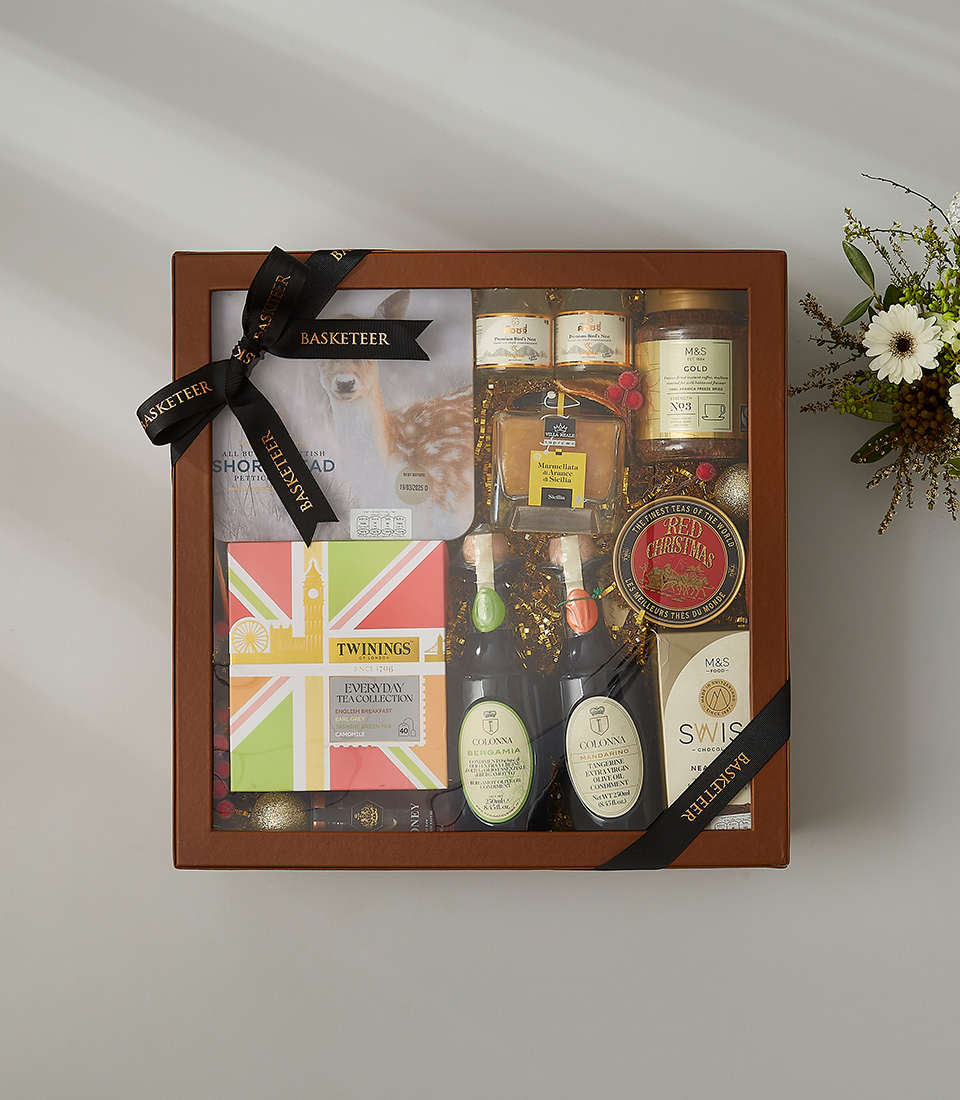 Festive holiday gift box with shortbread, Twinings tea, Christmas tea, honey, and gourmet chocolates.