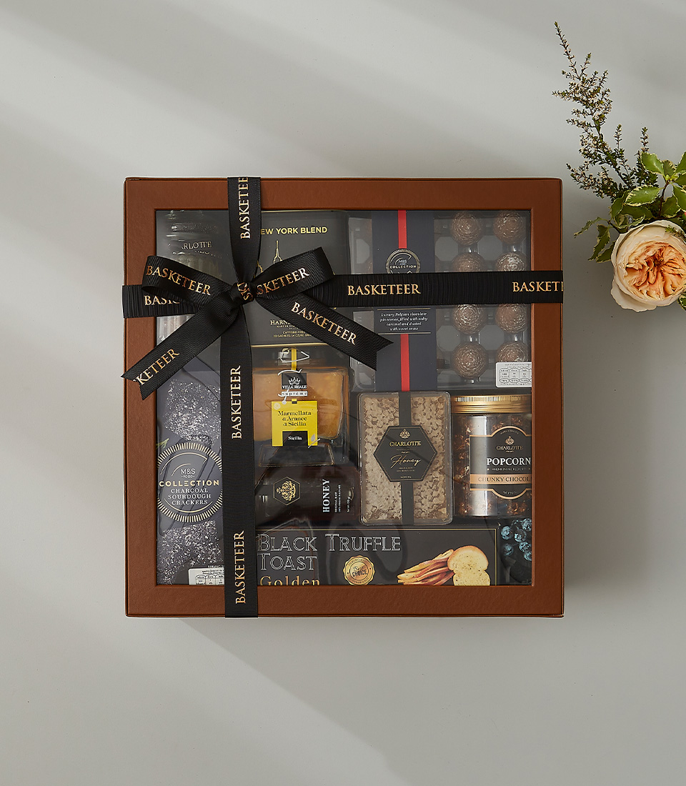 Luxury gift box with black truffle toast, premium chocolates, salted caramels, honey, and gourmet snacks.