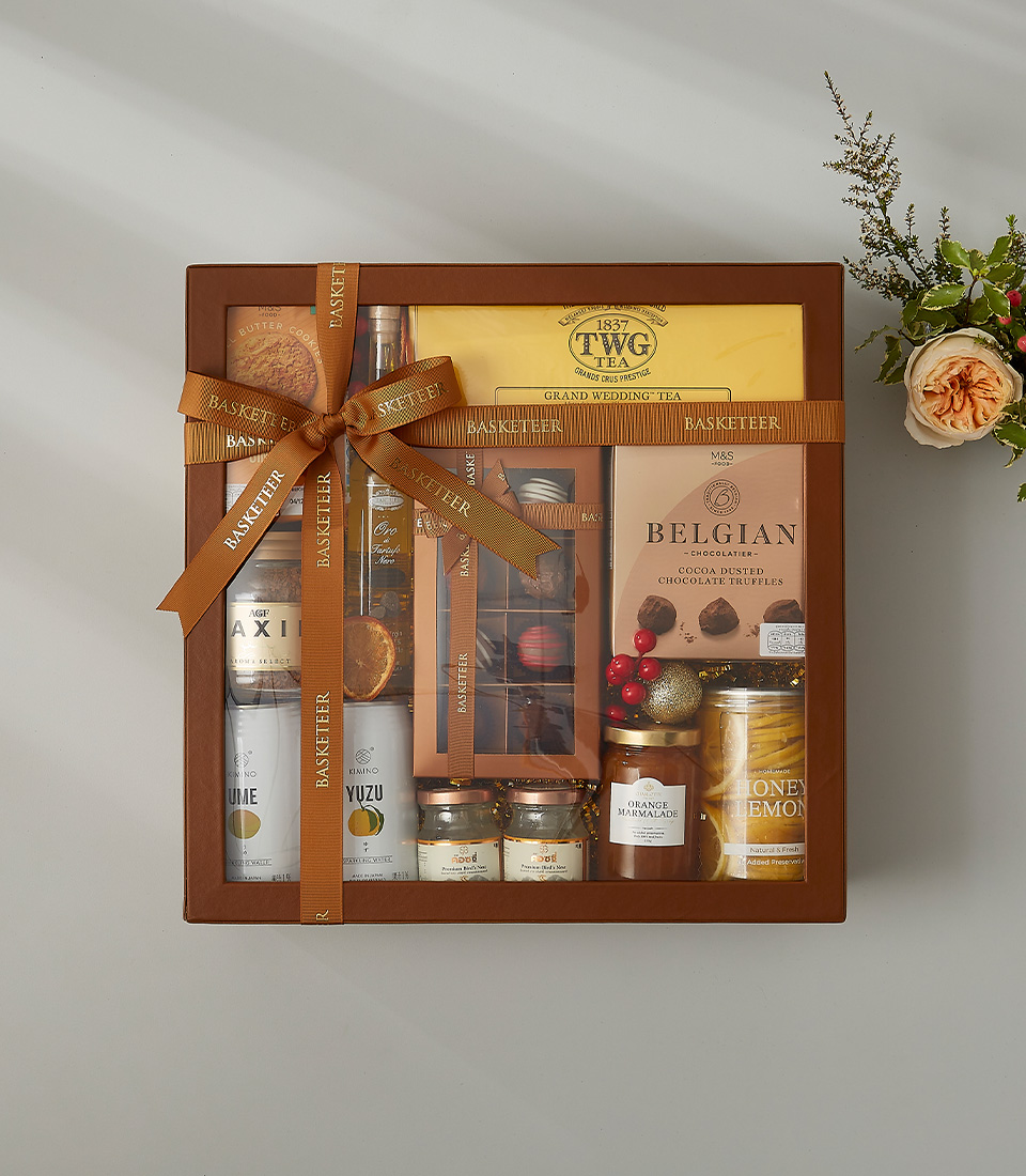 Elegant gift box with TWG tea, Belgian chocolate truffles, honey lemon, gourmet cookies, and preserves.