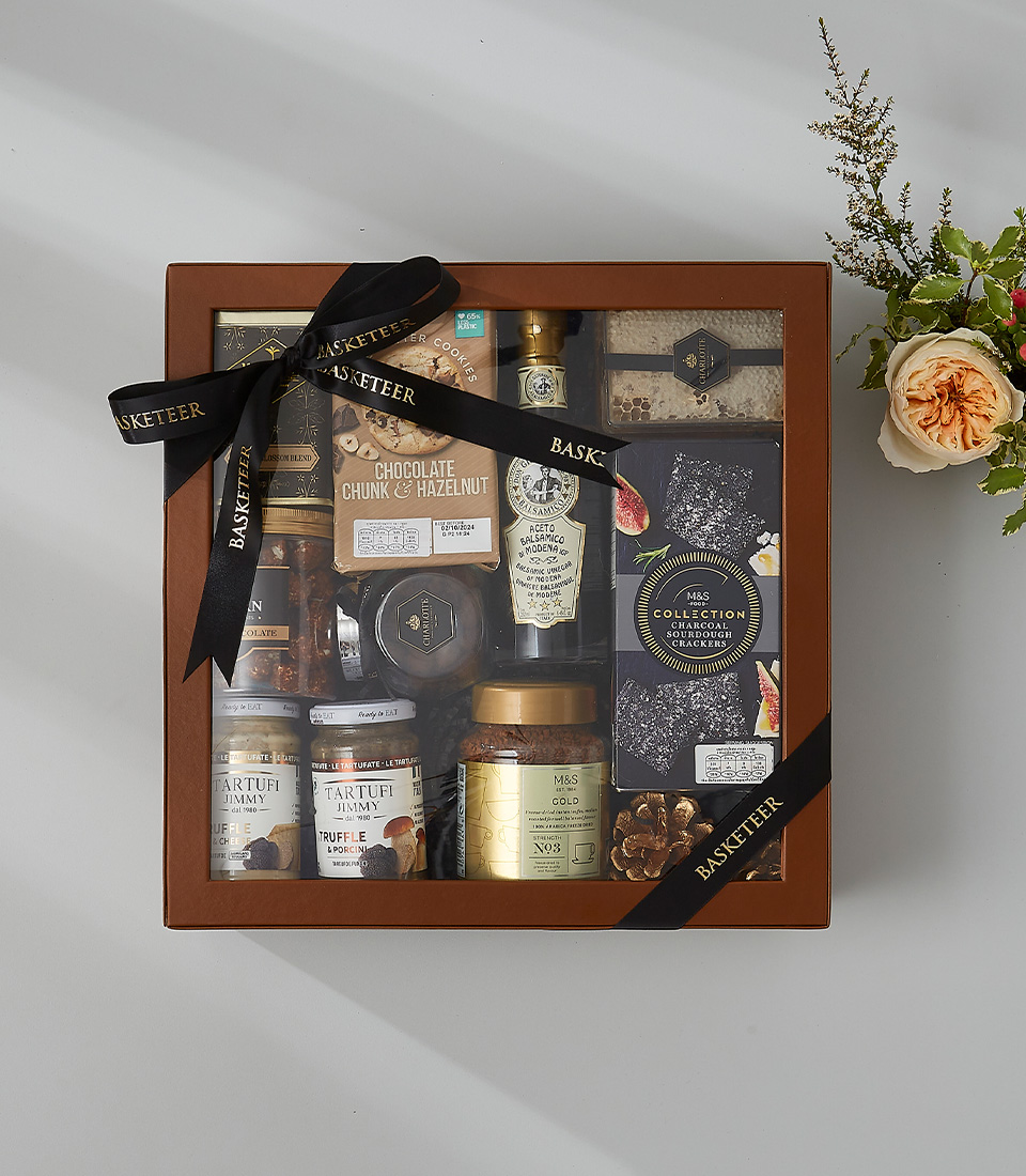 Premium gourmet gift hamper featuring truffle spreads, balsamic vinegar, honeycomb, crackers, chocolate, and artisanal delicacies.