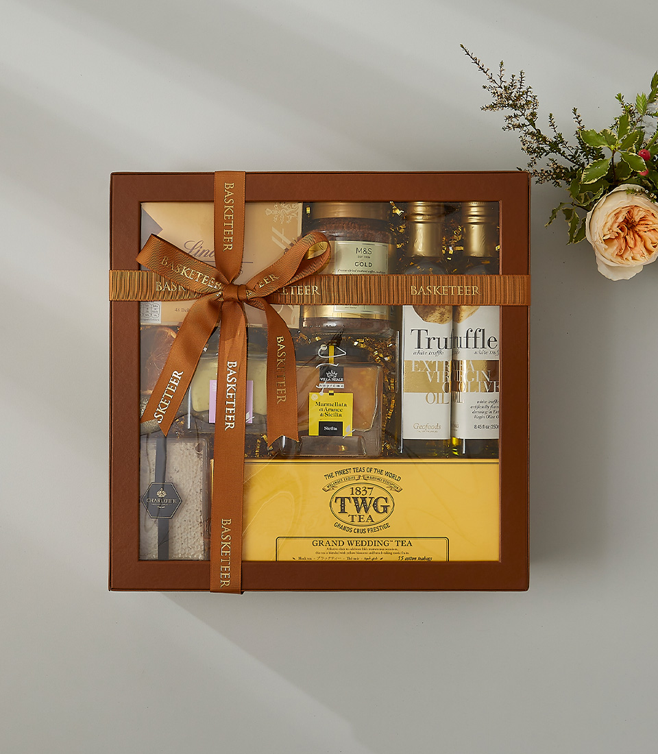 Luxurious gift box featuring premium truffle olive oil, TWG Grand Wedding Tea, marmalade, and gourmet treats tied with an elegant gold ribbon.