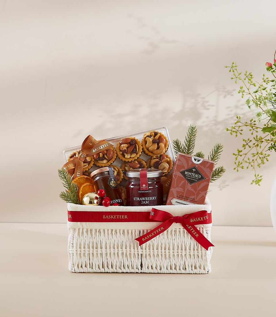 A white wicker basket filled with a variety of gourmet food items.