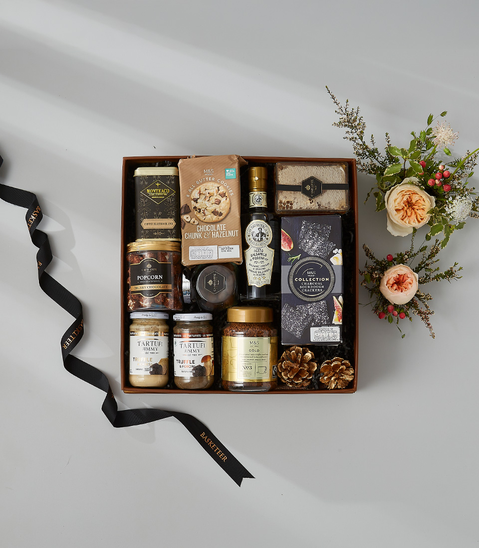 Luxury gourmet gift box with premium chocolates, truffle jam, cookies, honeycomb, and artisan snacks.