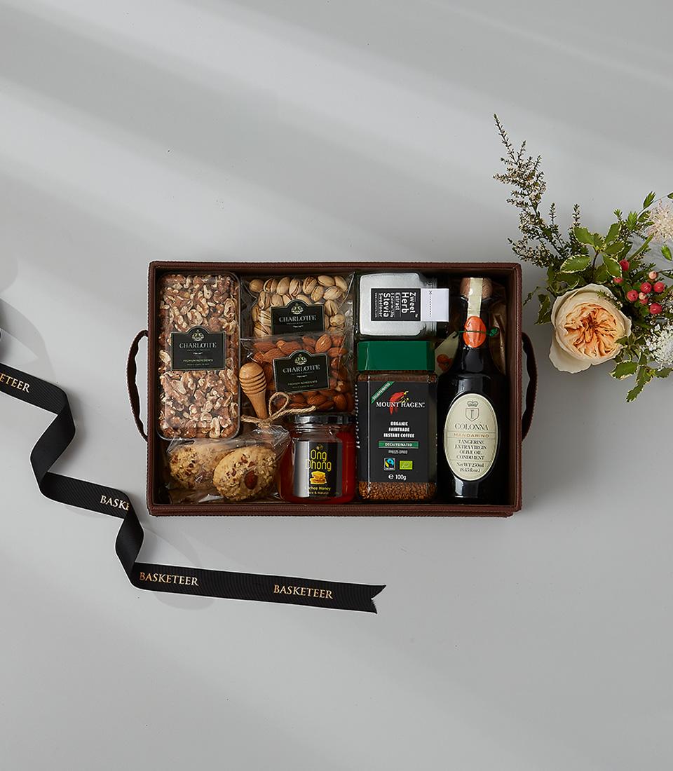 Gourmet gift box with assorted nuts, honey, organic coffee, balsamic vinegar, and cookies.