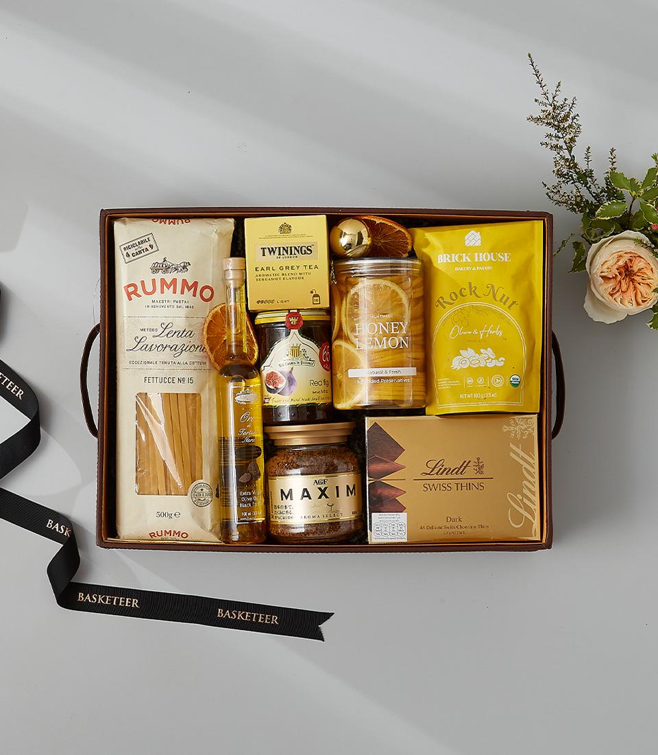 Gourmet gift box with pasta, Earl Grey tea, honey lemon slices, nuts, and chocolates.