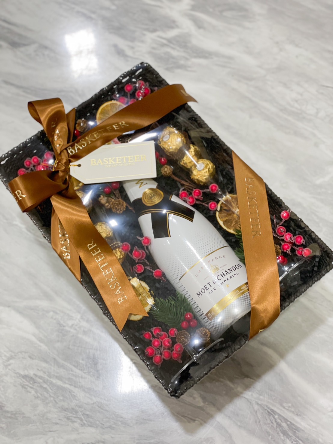 Luxury gift basket with Ferrero Rocher chocolates, festive decor, and a premium bottle by Basketeer.
