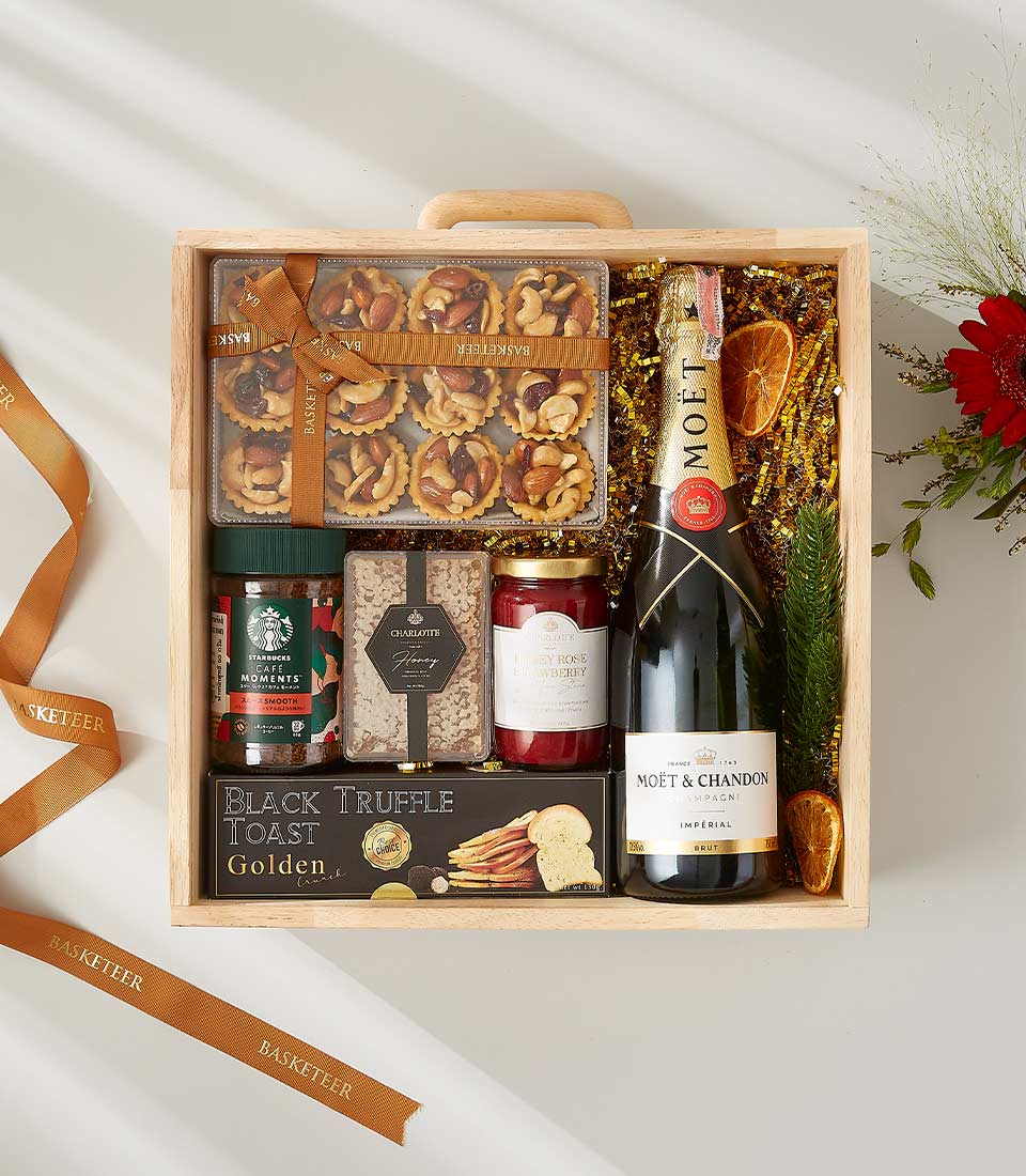 Wooden gift box with Moët & Chandon champagne, gourmet snacks, black truffle toast, honey, jam, and a Starbucks coffee blend.