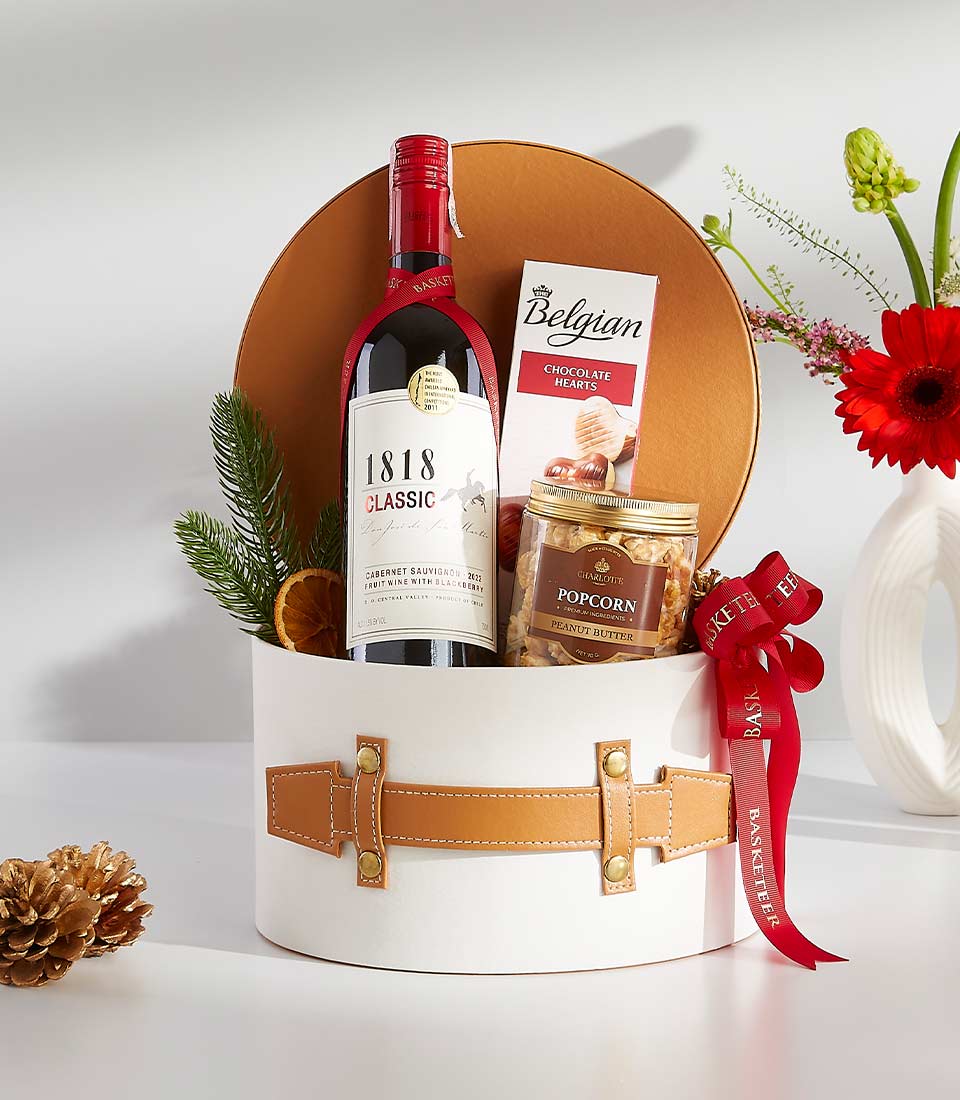 Luxury gift hamper containing a bottle of wine, gourmet snacks, and chocolates.