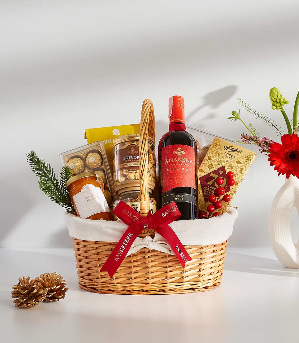 Luxury gift hamper containing a bottle of wine, gourmet snacks, and chocolates.