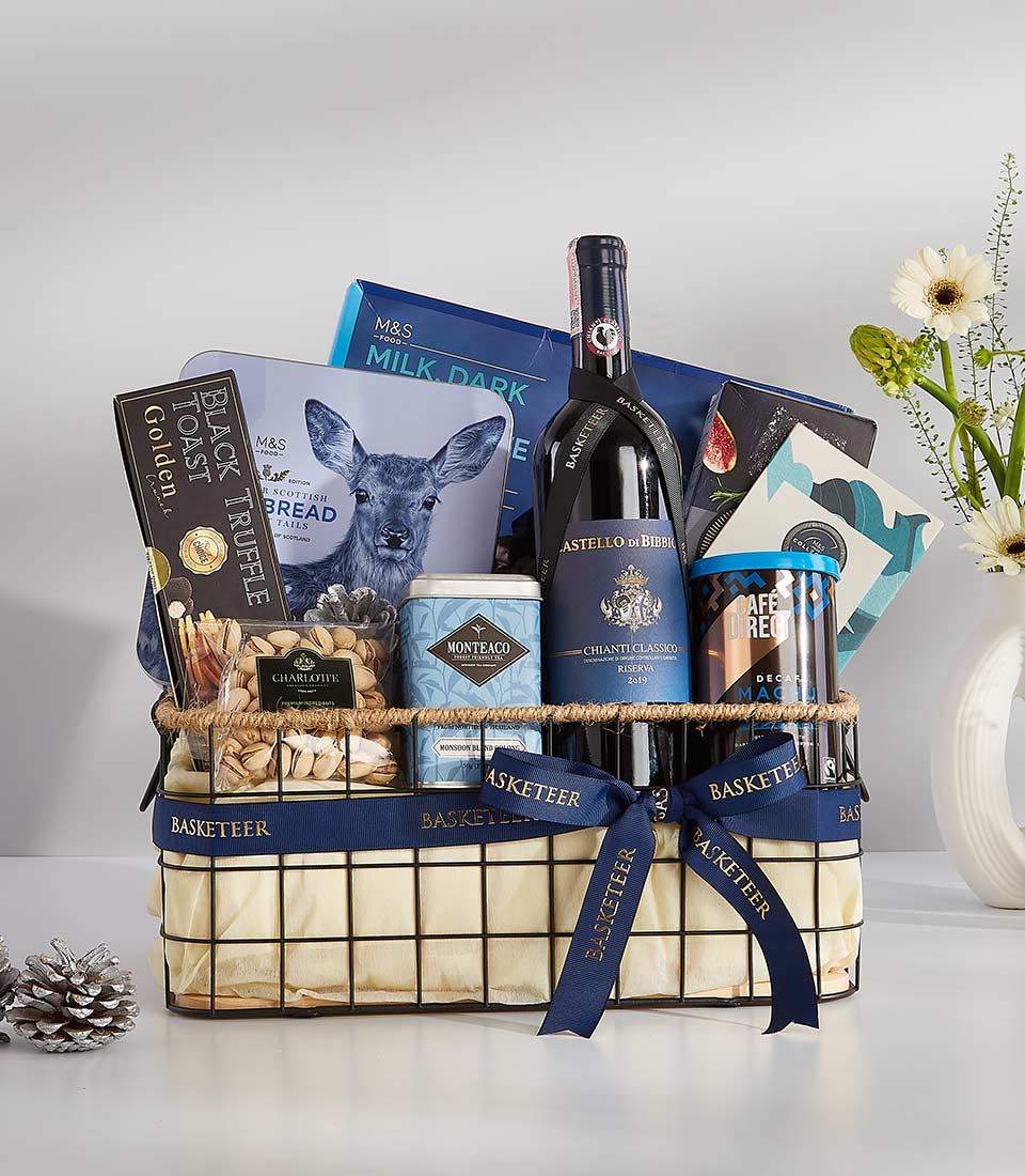 A stylish, navy blue gift basket filled with a variety of gourmet treats, including chocolate, crackers, nuts, and a bottle of wine.