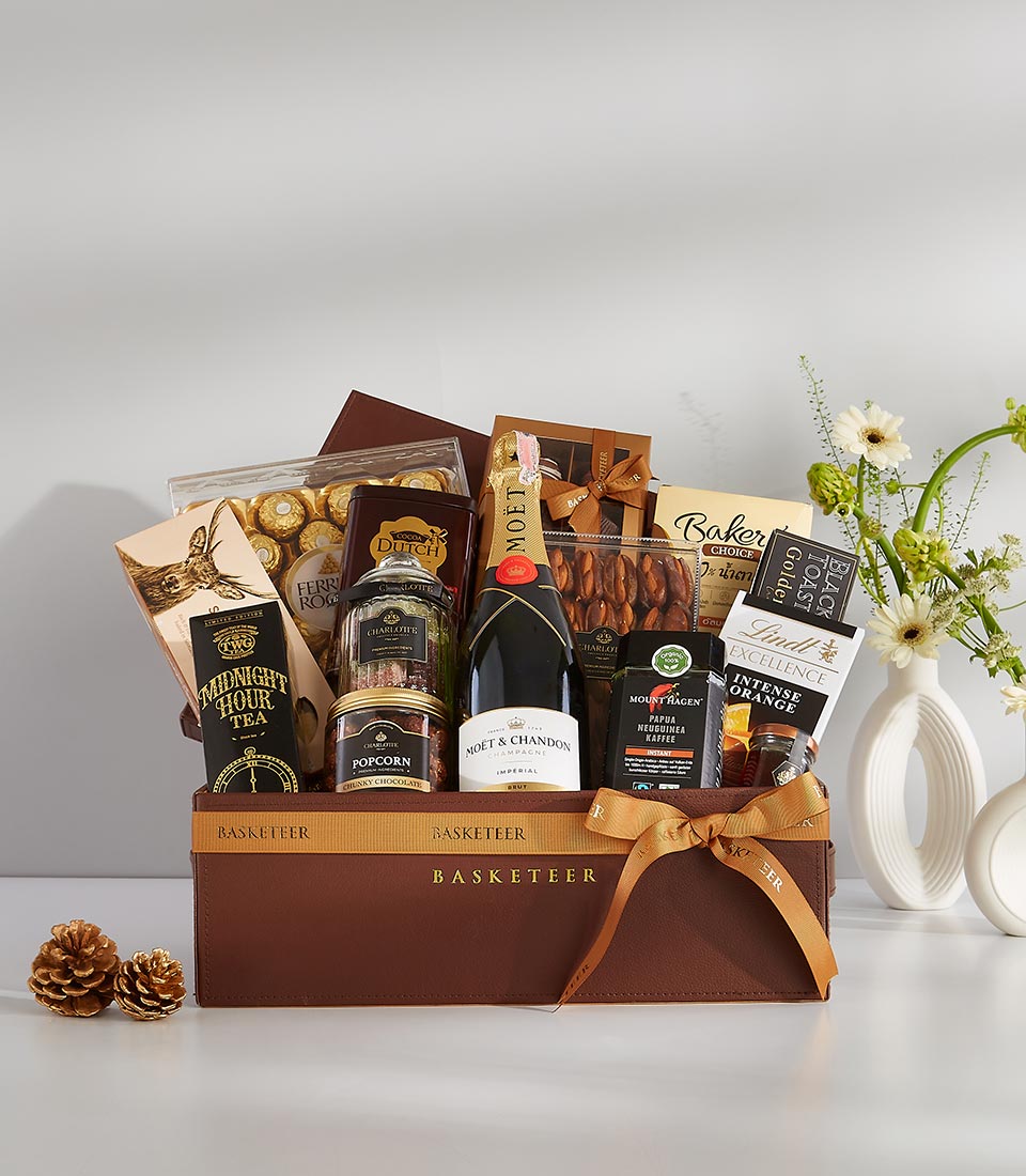 A luxurious gift basket filled with gourmet treats including a bottle of Moët & Chandon champagne, assorted chocolates, gourmet coffee, and more.