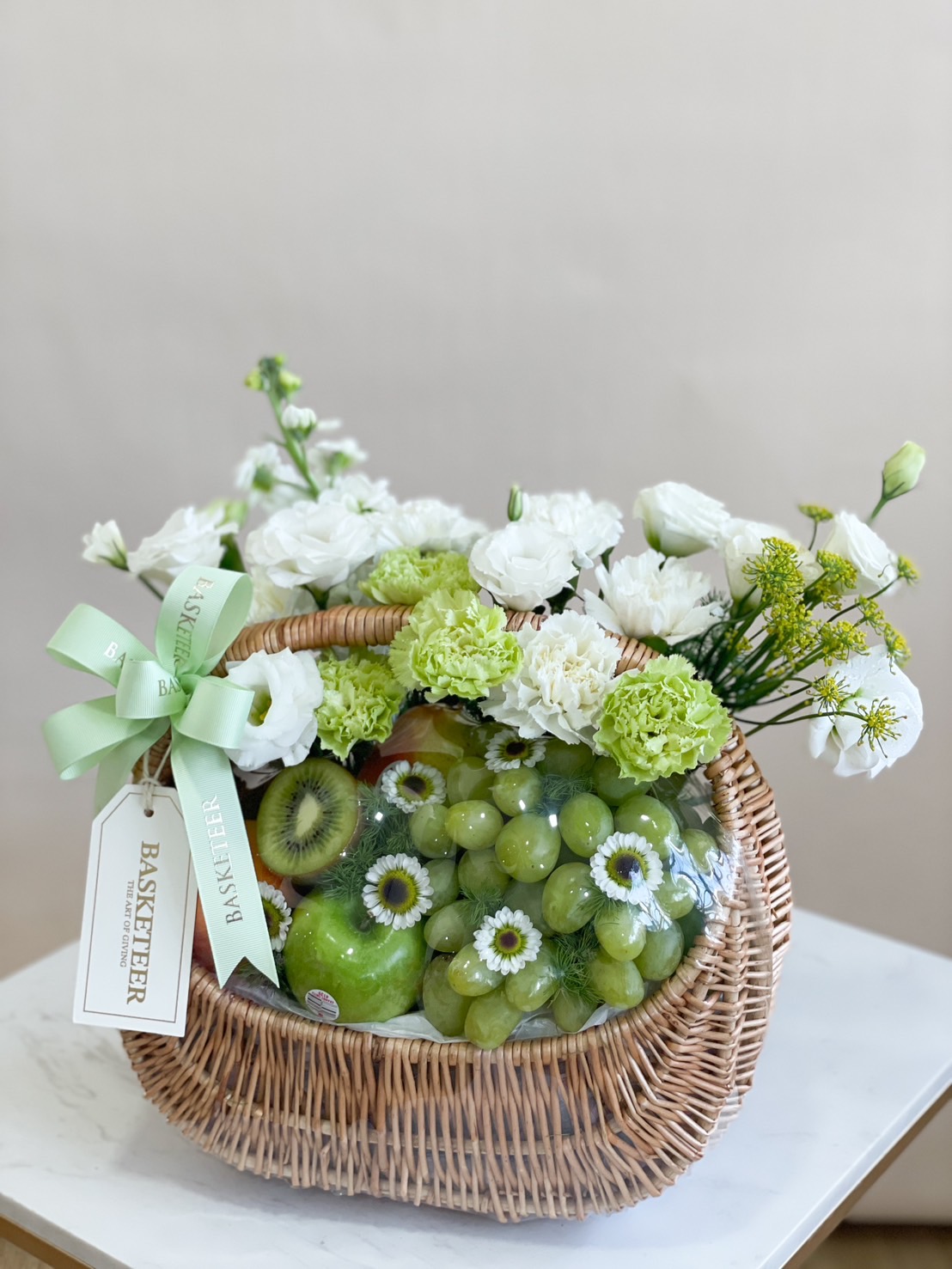 Fresh Harmony Fruit Basket with green apples, pears, kiwi, grapes, and white flowers.