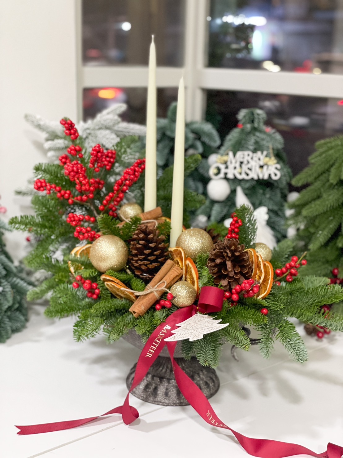 Holiday centerpiece with red berries, pinecones, golden ornaments, candles, and nutcracker figurines.