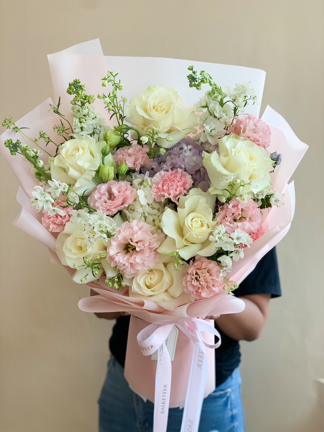 A luxurious pastel bouquet of white roses, pink carnations, and soft hydrangeas, wrapped in elegant blush pink paper, perfect for romantic occasions & heartfelt gifts.