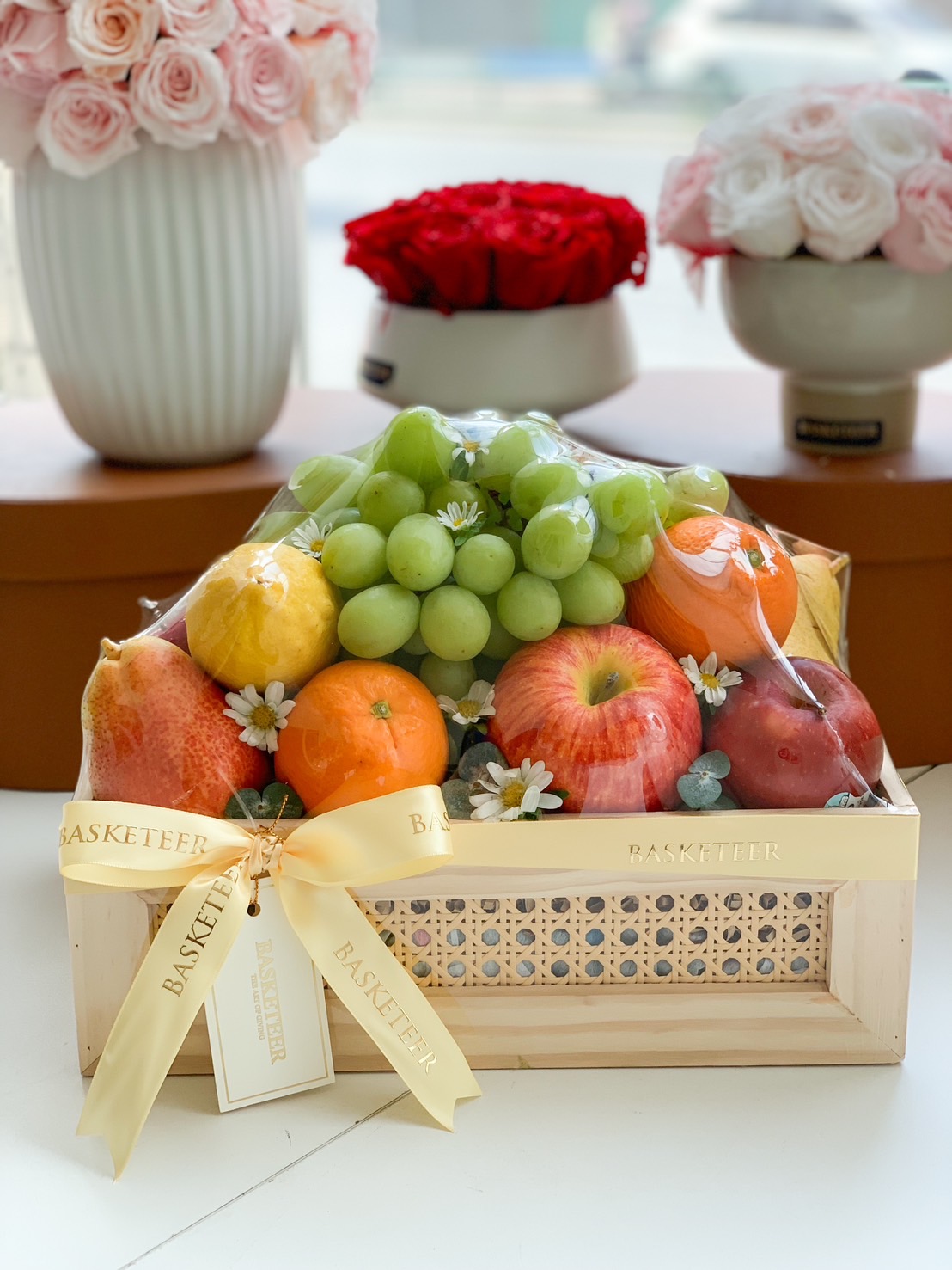 A luxurious fresh fruit gift basket filled with premium apples, grapes, pears, oranges, and more, beautifully arranged in a handcrafted wooden basket with an elegant golden ribbon. A perfect choice for health-conscious gifting, celebrations, and corporate events.