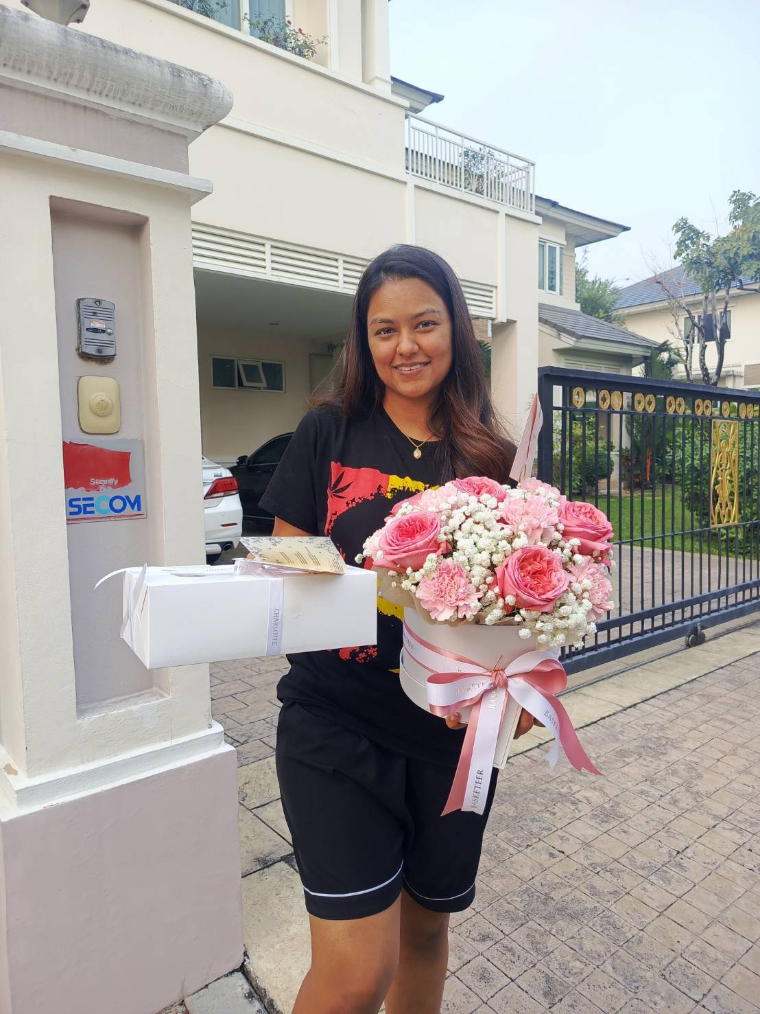 A stunning pink rose and baby’s breath floral arrangement in a luxury Basketeer hatbox, tied with a soft pink ribbon—ideal for romantic and special occasions.