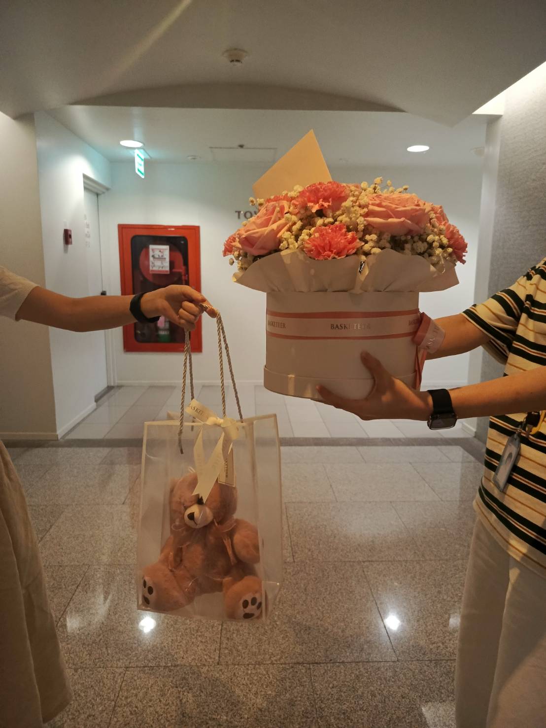 Elegant pink rose and carnation flower hatbox with a soft plush teddy bear in a gift bag—ideal for expressing love and appreciation.