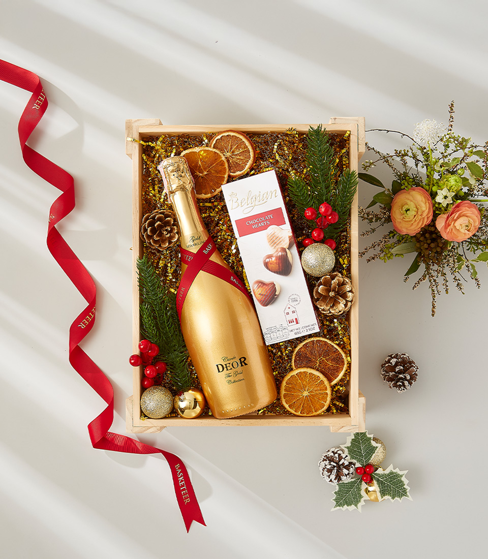 A luxurious gift hamper containing a fine bottle of champagne, premium Belgian chocolates, and elegant holiday accents.