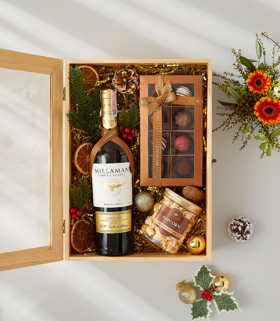 A luxurious and elegant gift basket filled with a bottle of champagne, gourmet chocolates, and festive decorations.