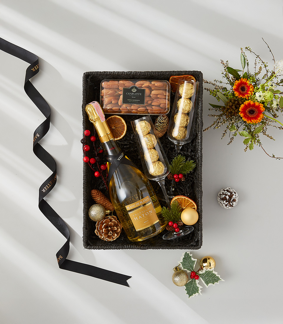 Festive gift box containing a bottle of Moët & Chandon champagne, gourmet chocolate, and two champagne flutes.