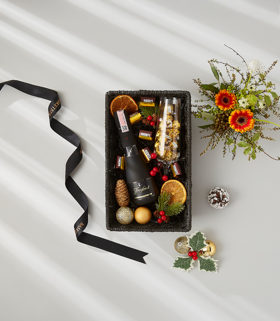 Festive gift box containing a bottle of Freixenet Prosecco, Hershey's chocolate, and two champagne flutes.