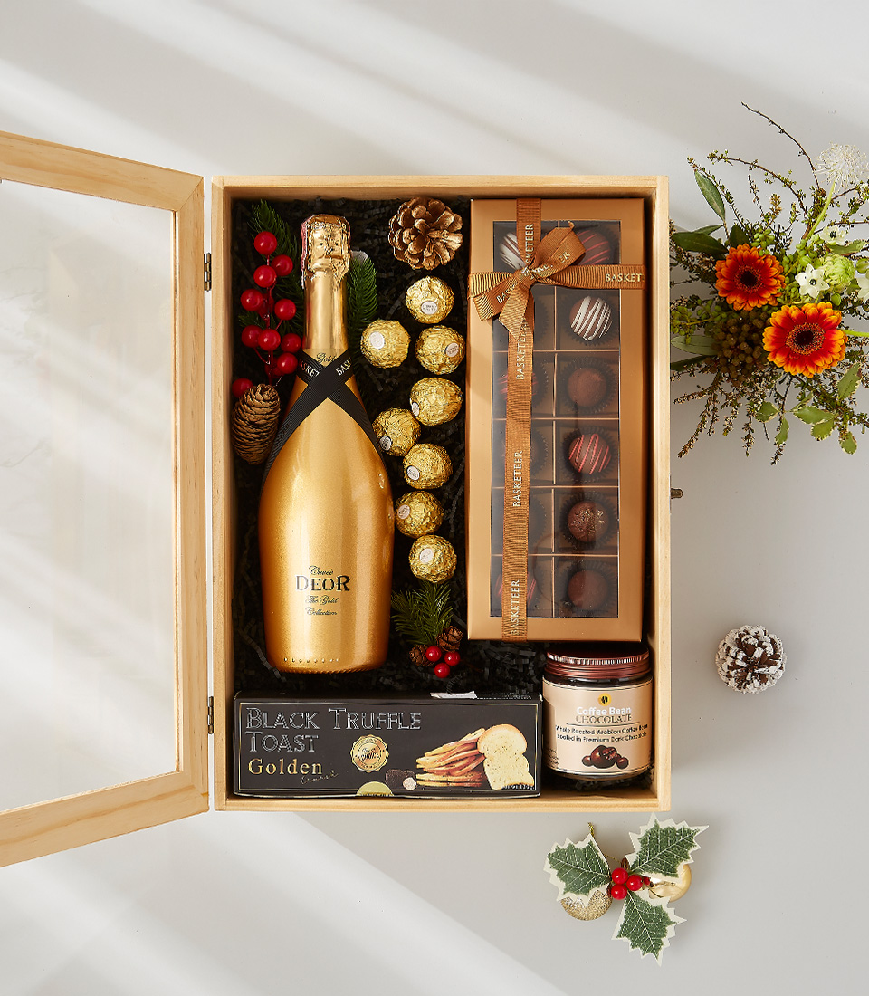 A festive gift hamper filled with a golden bottle of champagne, delicious snacks, and festive decorations.
