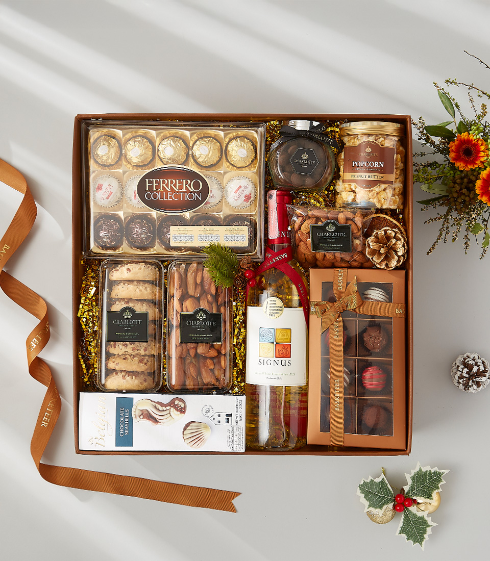 a festive gift box filled with a bottle of wine, decadent snacks, and holiday-scented candles.