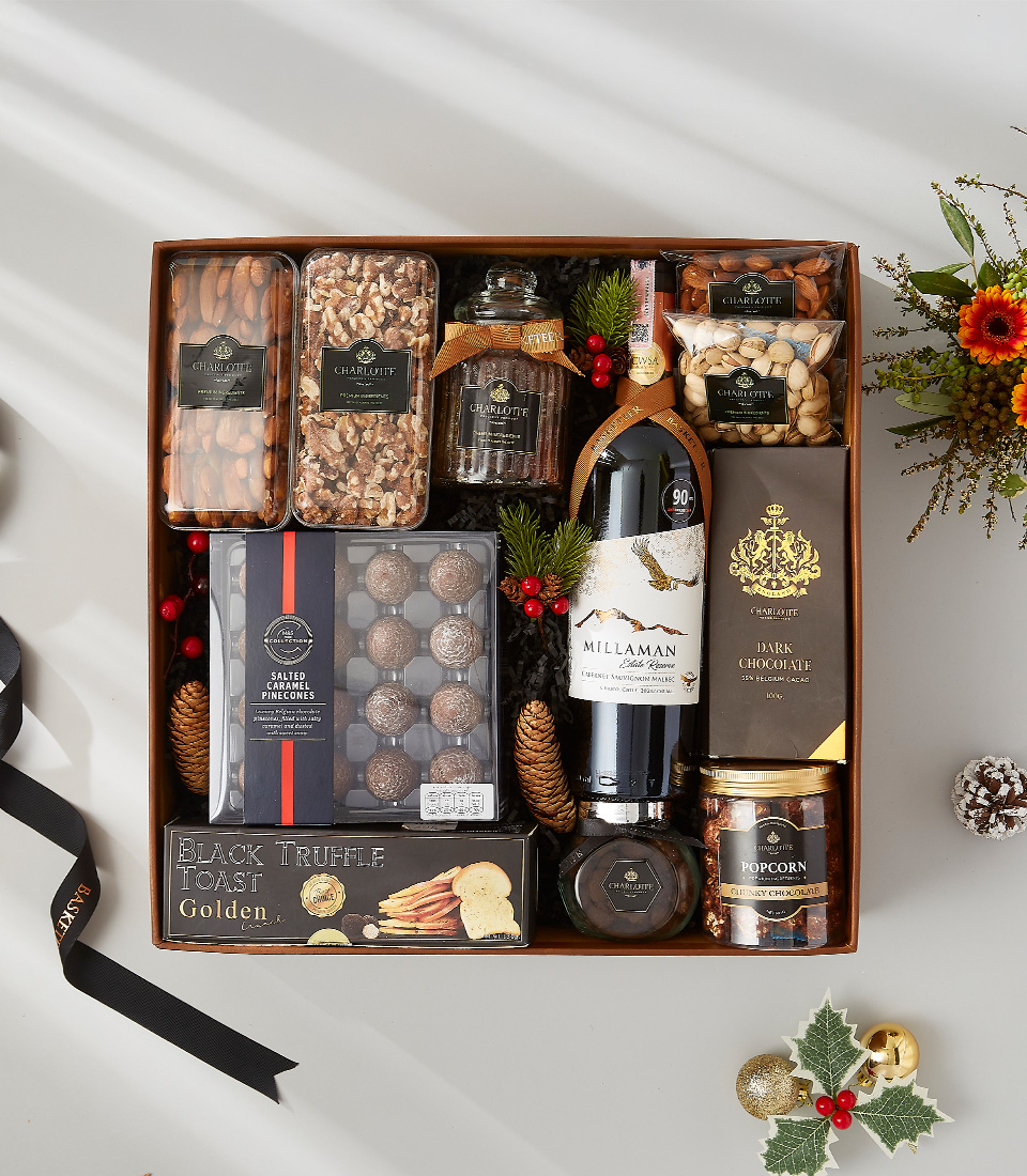 A luxurious and elegant gift basket filled with a bottle of wine, gourmet snacks, and holiday decorations.